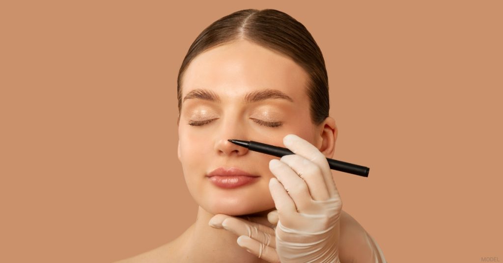 Provider marking a woman's nose in preparation for rhinoplasty (model)